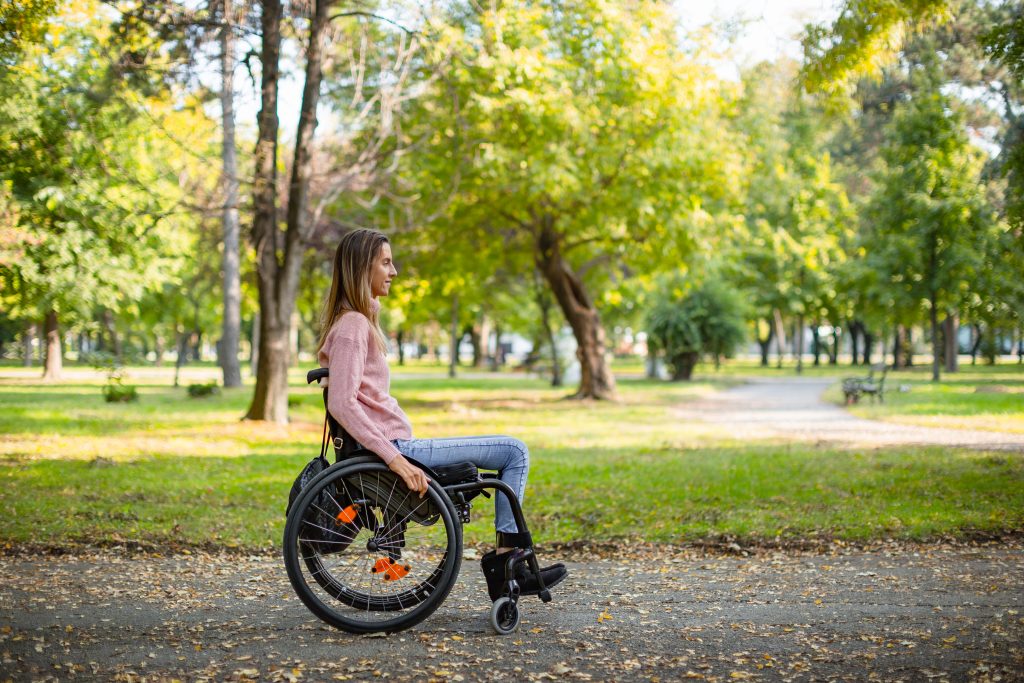 Young woman in wheelchair in park