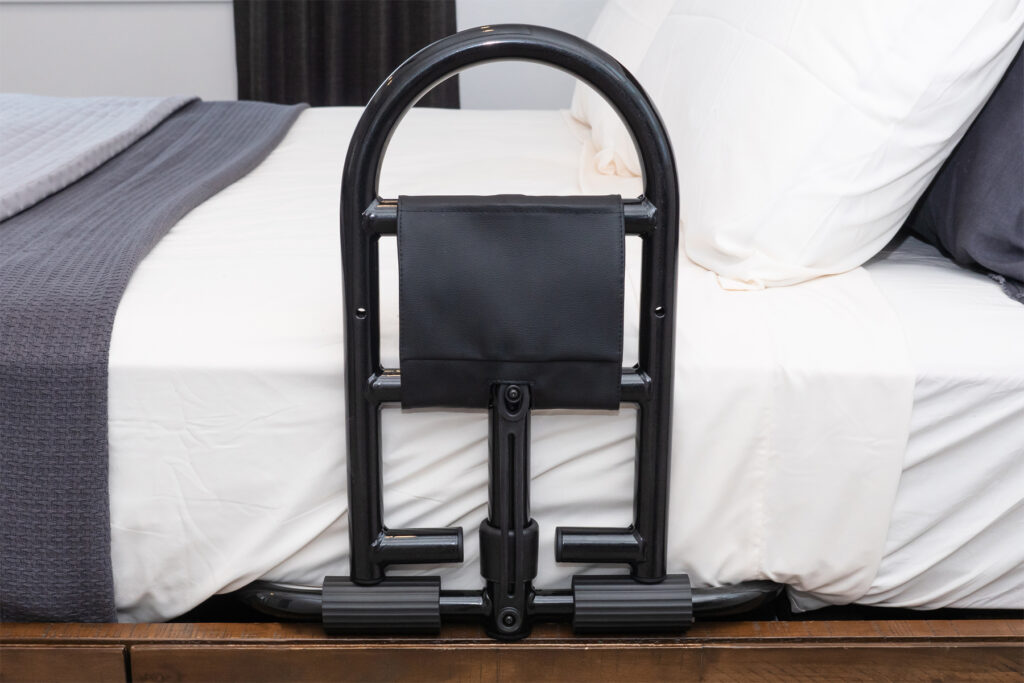 A Prime Bed Handle attached to the side of a white and grey bed.