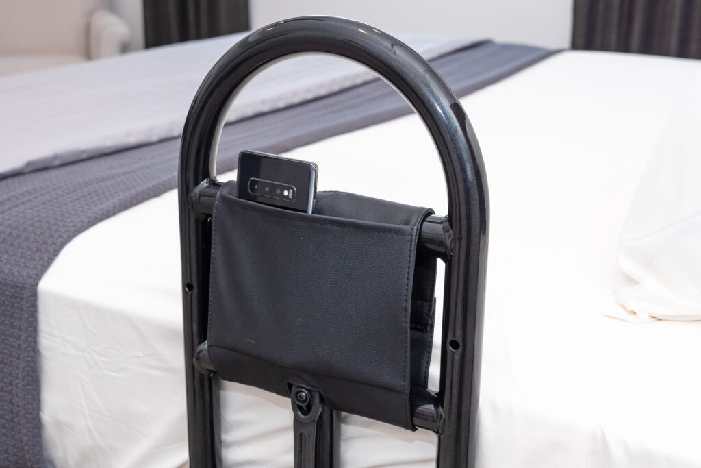 A close up of a black Prime Bed Handle attached to a white and grey bed.