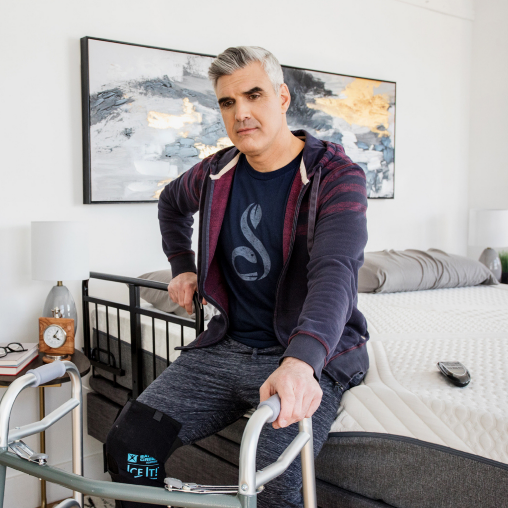 A man getting out of bed suing his Harmony Hi-low adjustable base.