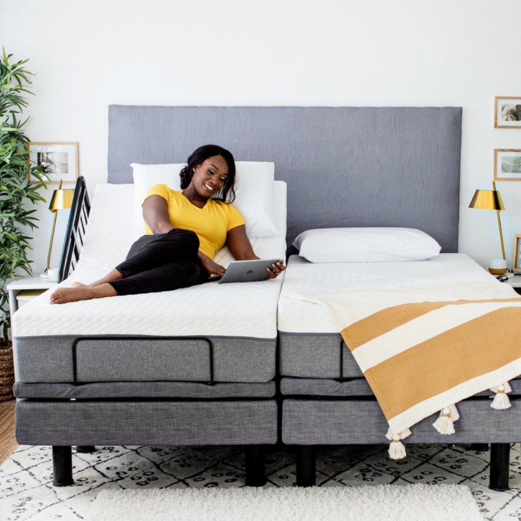 A woman laying on her bed with a Harmony Hi-low adjustable base.
