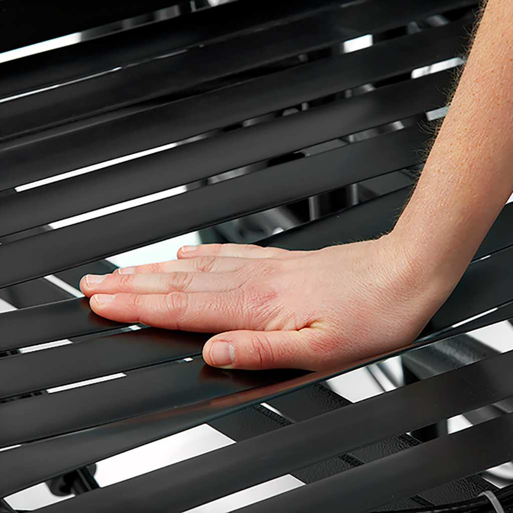 A hand touching the seating surface of a wheelchair