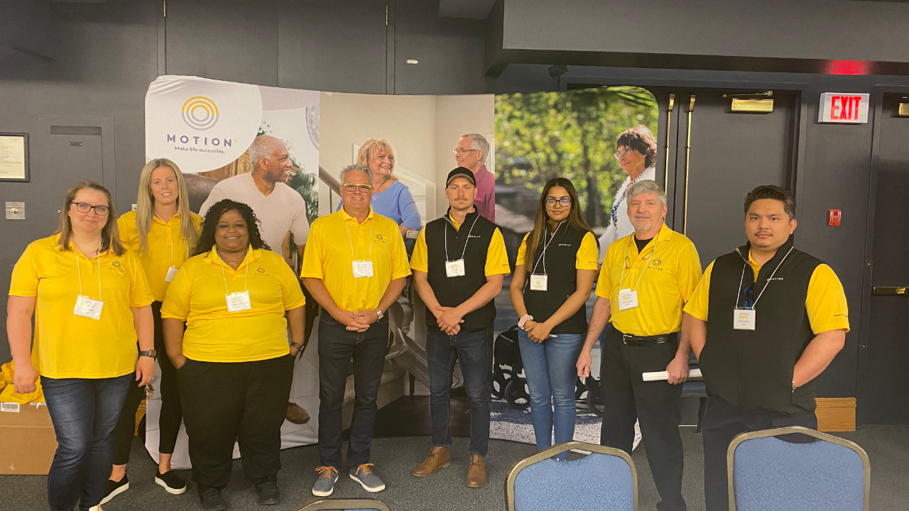Motion Winnipeg team members wearing Motion-branded yellow golf shirts at the 2022 Motion Rehab Expo